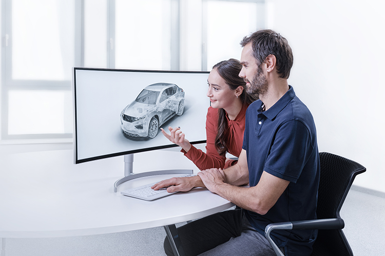 Two people looking at a vehicle design on a screen