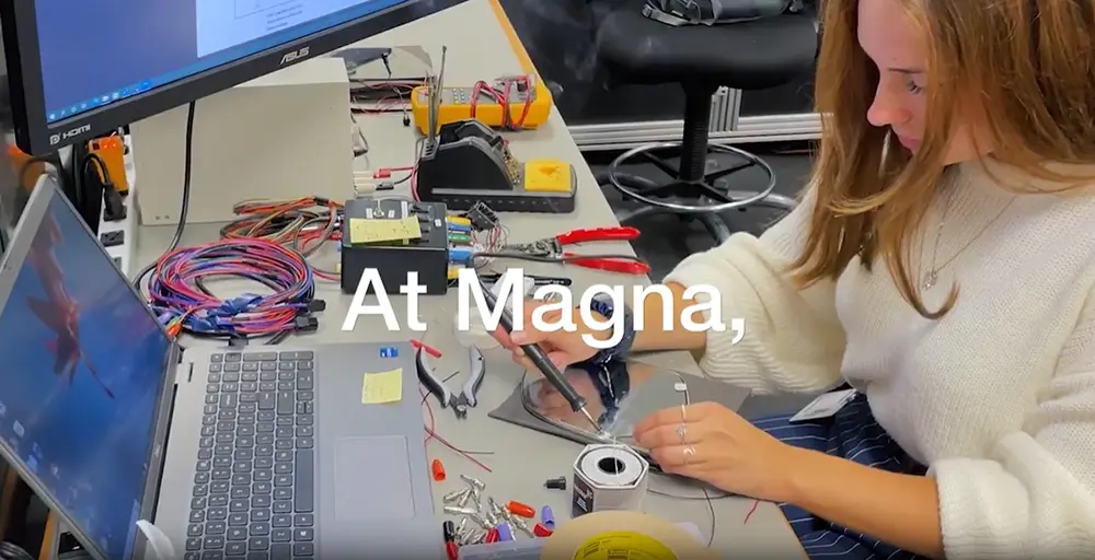 Person sitting in front of a laptop using a soldering iron