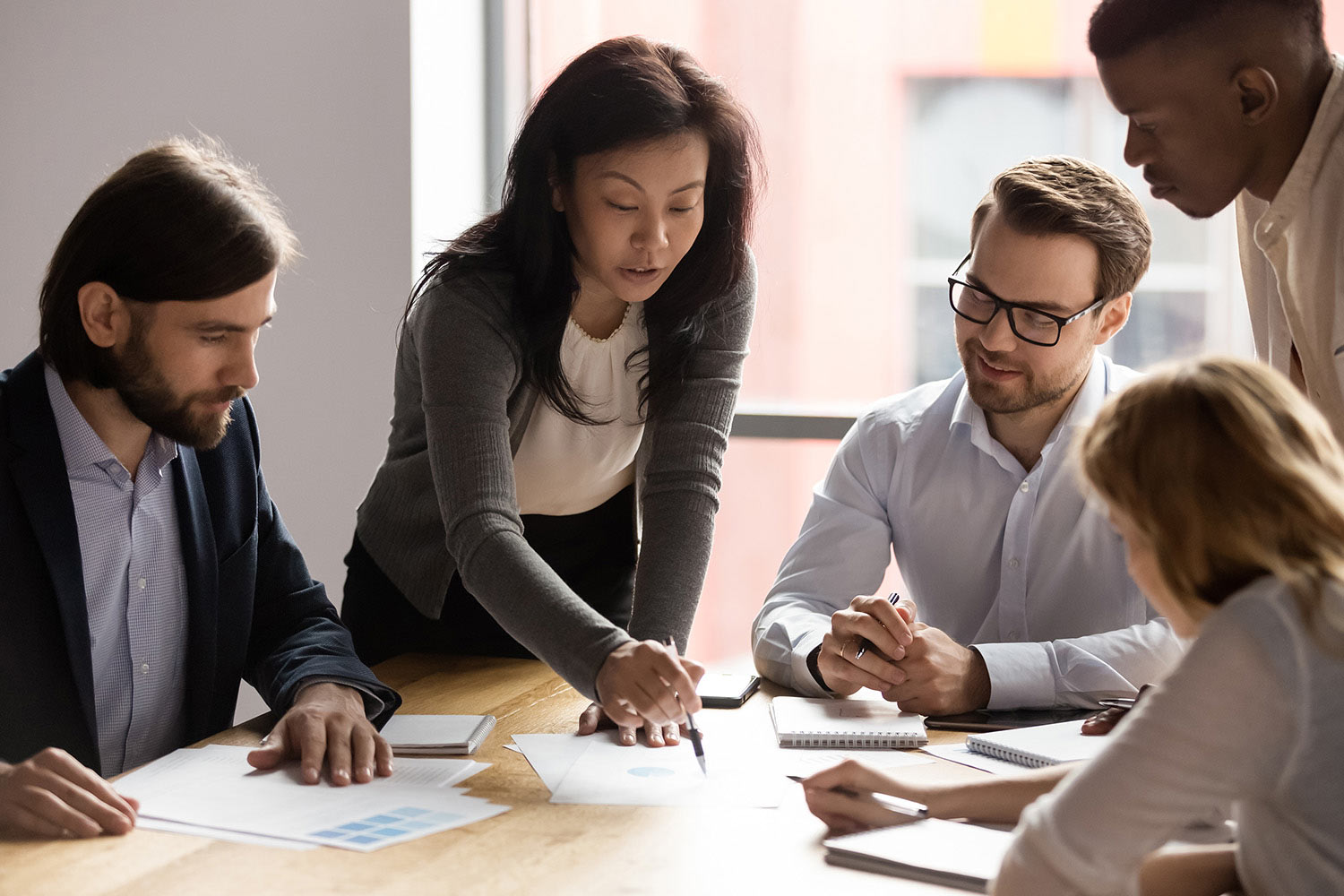 A woman explaining something to her diverse colleagues