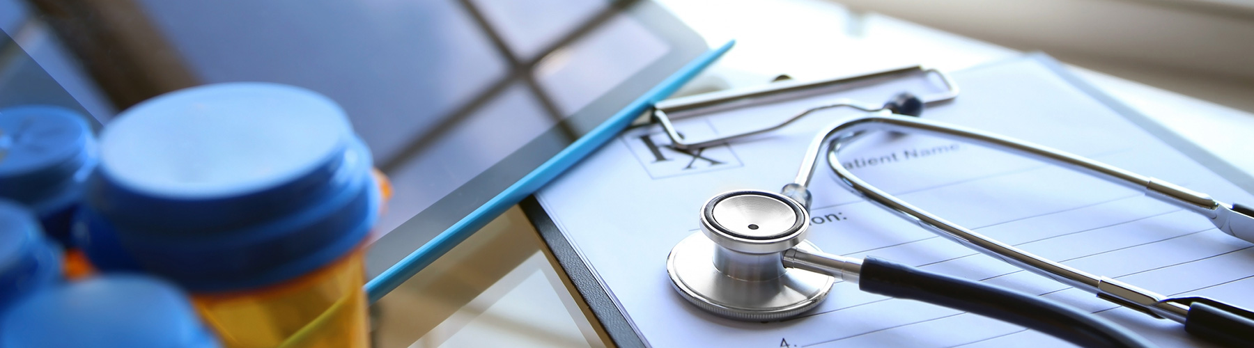 iPad, stethoscope, pill bottle and pad of paper