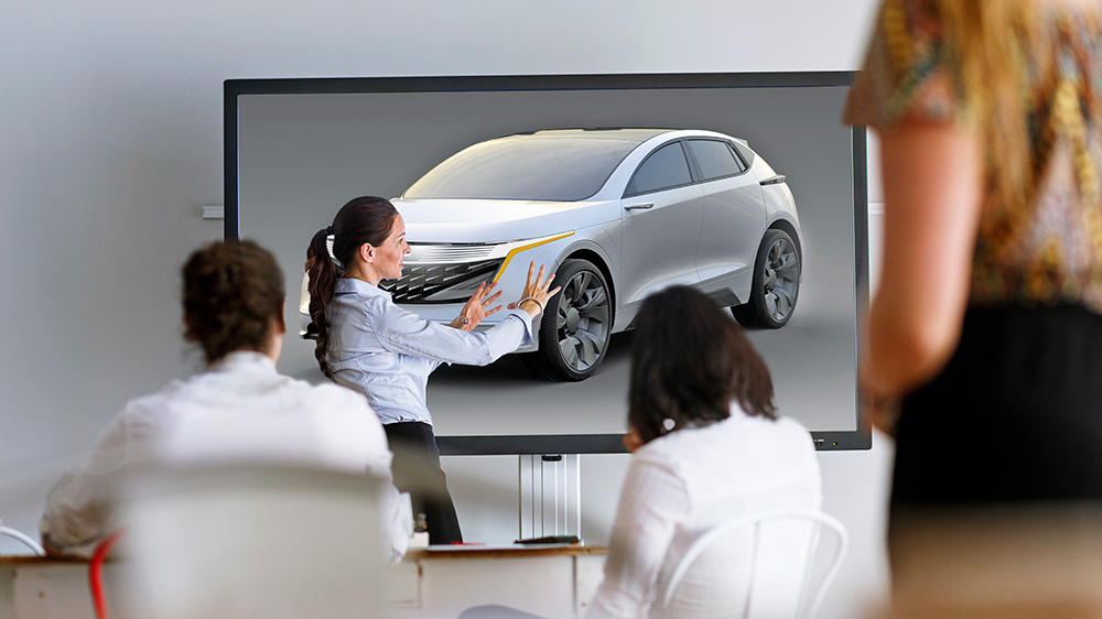 Person giving a presentation with a vehicle on the screen