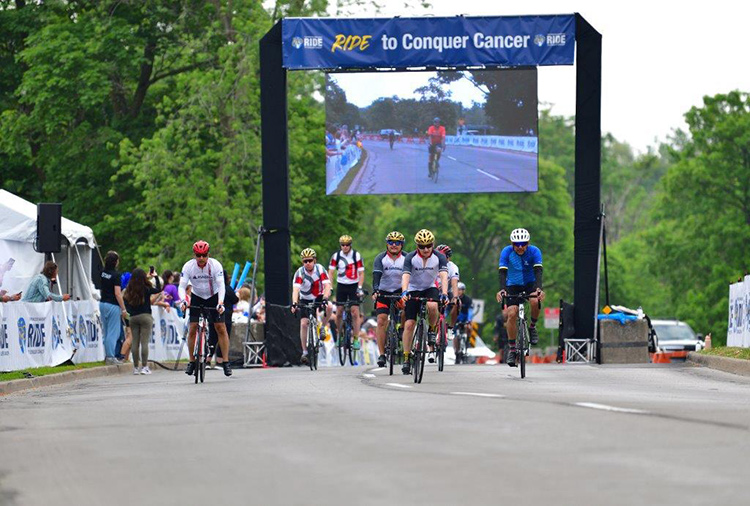 Magna riders crossing the finish line for the Ride to Conquer Cancer