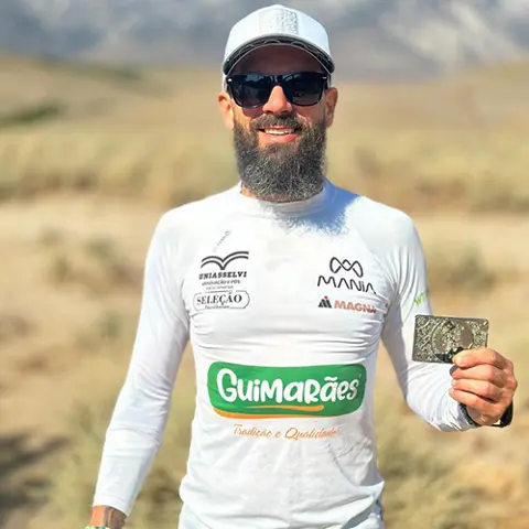 Tiarles Dos Santos holding up a silver plaque in a field